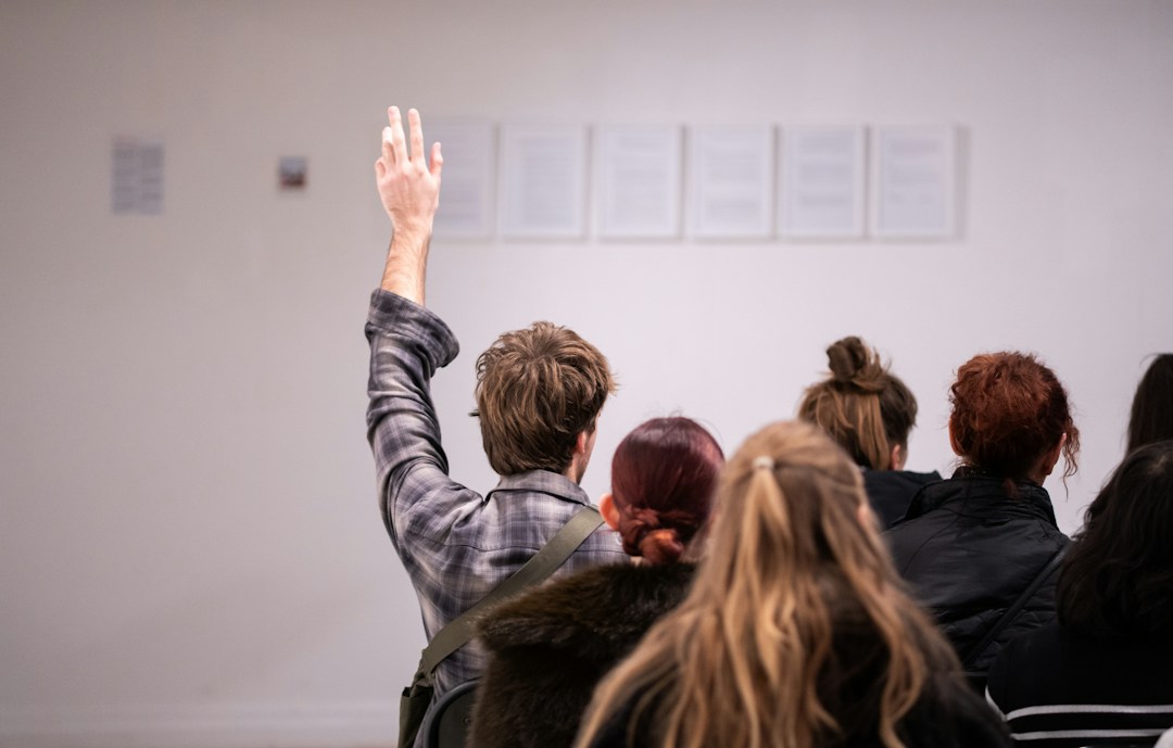 Thementage Vortrag Publikum (Unsplash W1HWLCLDeN4) Publikum bei einem Vortrag, eine Person meldet sich